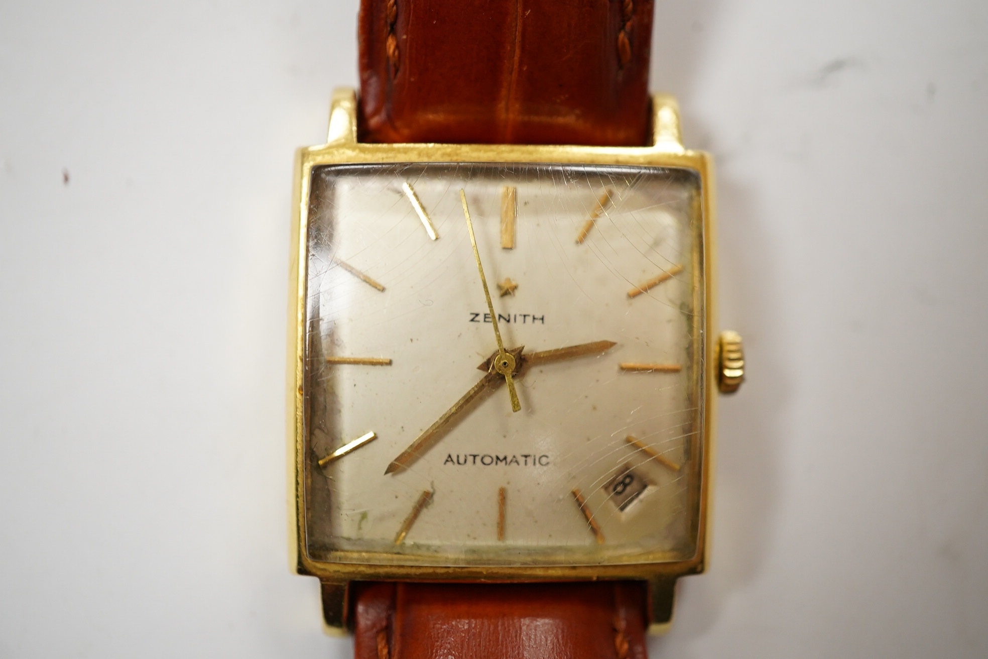 A gentleman's 18k Zenith Automatic square dial wrist watch, with baton numerals and date aperture, on an associated leather strap, case diameter 30mm. Condition - poor.